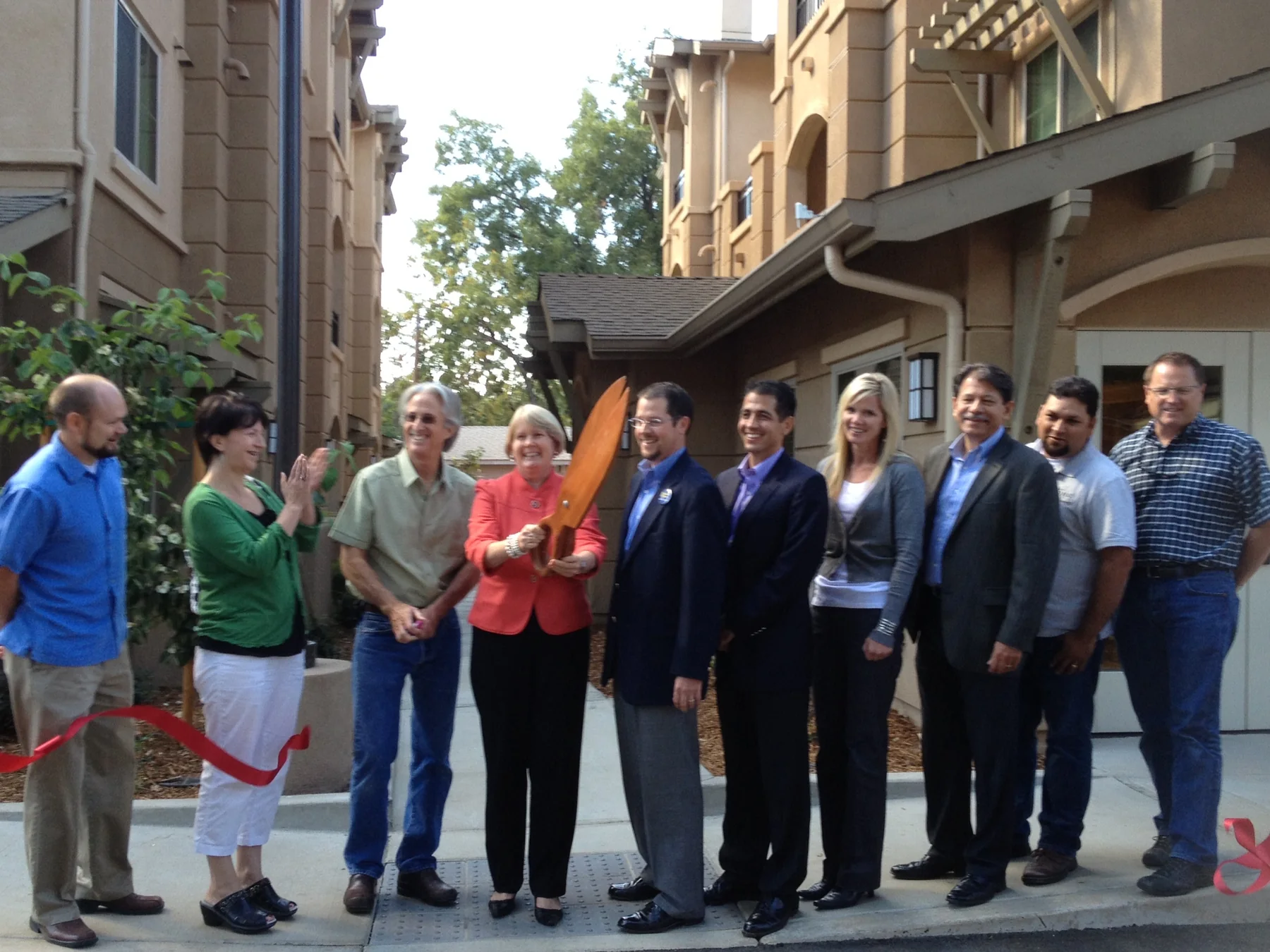 Bidwell Park Apartments ribbon cutting with project partners gathered outside