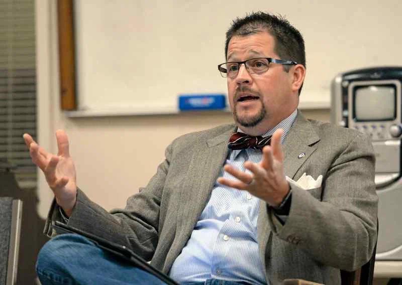 Randall Stone seated during a professional discussion